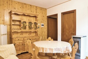 Une pièce avec une table ronde, des meubles en bois et un four à micro-ondes.