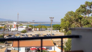 A coastal view with a parking lot, buildings, and a clear sky. - Sea Breeze Apartment - D. Ana Beach (Lagos)