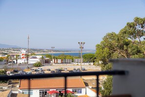 Blick auf die Küste mit einem Parkplatz, Gebäuden und blauem Himmel.