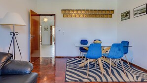 A dining area with a zebra-patterned rug, blue chairs, and a table. - Sea Breeze Apartment - D. Ana Beach (Lagos)