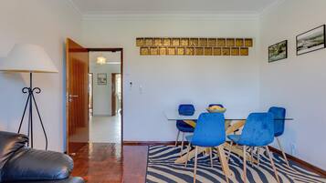 A dining area with a zebra-patterned rug, blue chairs, and a table.