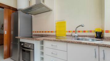 A kitchen with a stainless steel refrigerator, oven, and a modern faucet.