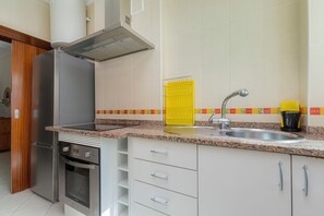Eine Küche mit Kühlschrank aus Edelstahl, Backofen und einem modernen Wasserhahn.
