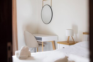 A hotel room with a bed, a desk, a chair, a lamp, and a towel on the bed. - Brise Marine Apartment - D. Ana Beach (Lagos)