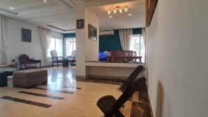 A spacious living area with a pool table, comfortable seating, and a view of the outdoors. - Luxurious 3-bedroom Apartment in Heart of Tunis (Tunis)