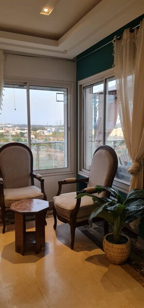 A room with two chairs, a small table, and a potted plant. - Luxurious 3-bedroom Apartment in Heart of Tunis (Tunis)