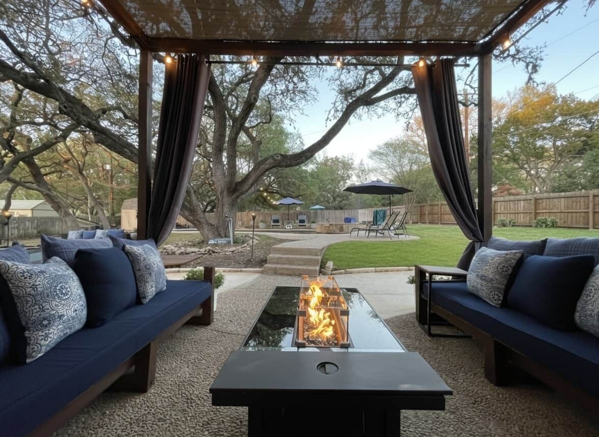 Eine Terrassensitzgruppe mit Feuerstelle, zwei Sofas und einer Pergola.