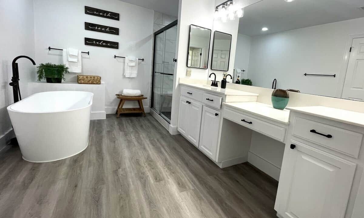 Un baño moderno con una bañera independiente, cabina de ducha de vidrio y tocador con espejo.