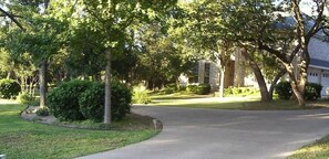 Uma entrada de garagem residencial com um caminho sinuoso que leva a uma casa.