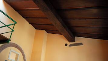 Une pièce dotée d’un plafond en pente, d’une arche en briques et d’une structure métallique verte.