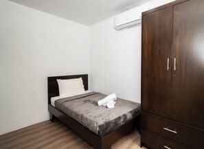 A small, neatly arranged bedroom with a bed, a wardrobe, and an air conditioning unit. - Casa Bamboo, Peaceful 3 bdr Jungle Home in Uvita, 2min from river and waterfalls (Uvita)
