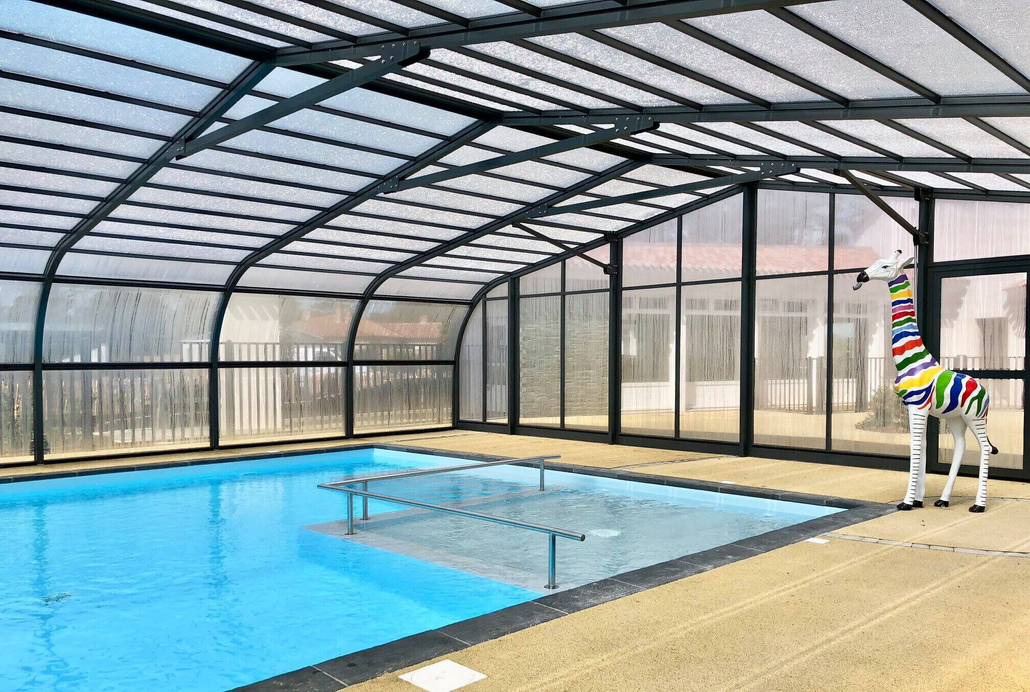 Une piscine couverte ornée d’une statue de girafe.