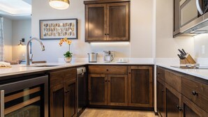 A modern kitchen with wooden cabinets, a stainless steel sink, and a coffee machine. - Paso Park Suites by Avantstay 2 Private Balconies + Town Square Views Downtown Paso Robles (Paso Robles)