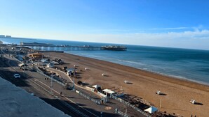 A beach with a pier extending into the sea, a parking area, and a clear sky. - Kings Residence 4 | By My Getaways (Brighton)
