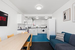 A compact living space with a kitchenette, a dining area, and a sofa. - Kings Residence 5 | By My Getaways (Brighton)