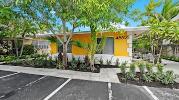 Edifício com fachada amarela, número 4552, cercado por um estacionamento e áreas verdes.
