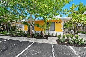 A building with a yellow facade, numbered 4552, surrounded by a parking lot and greenery. - Private 2BR Beach House - Walk to the Beach (Lauderdale-by-the-Sea)