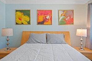 A bedroom with a bed, two nightstands, three wall-mounted paintings, and two lamps. - Private 2BR Beach House - Walk to the Beach (Lauderdale-by-the-Sea)
