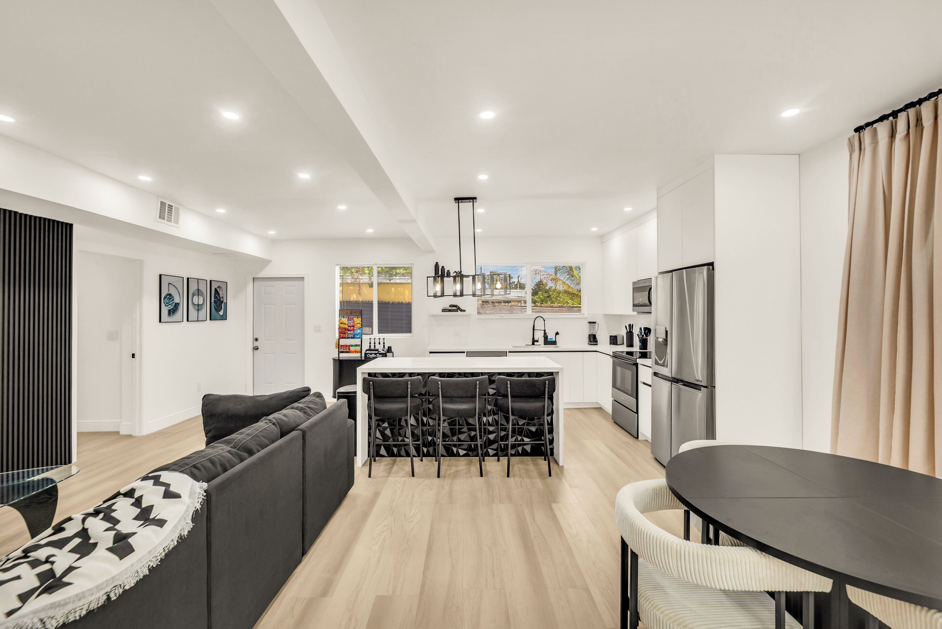 A modern apartment with a living area, kitchen, and dining space.