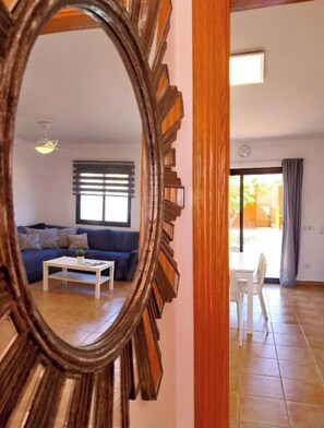 A living room with a sofa, coffee table, and a mirror reflecting the space. - Welcome, EstrellaMarina, to Corralejo, Fuerteventura! (Geafond)