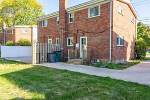A two-story brick apartment with a front porch, a white picket fence, and a small front yard. - Chic 2BR Oasis - Downtown Birmingham (Birmingham)