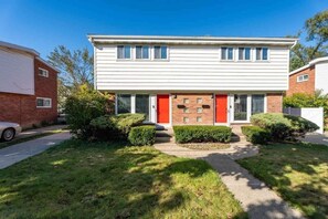 A two-story residential building with a red door, a brick facade, and a well-maintained lawn. - Chic 2BR Oasis - Downtown Birmingham (Birmingham)