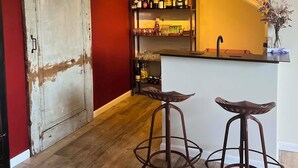 En bar med barstole, en stenvæg og en trædør.