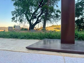 A patio area with a metal table and chairs, surrounded by grass and trees. - A wonderful B&B just a stone's throw from the city, nestled in a peaceful, natural setting (Marche)