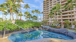 A hotel pool area with a clear pool, lounge chairs, and palm trees. - The Kaanapali Alii by Maui Resort Rentals (Kaanapali)