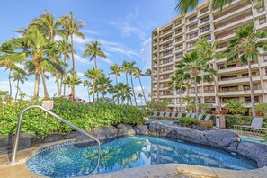 A hotel pool area with a clear pool, lounge chairs, and palm trees. - The Kaanapali Alii by Maui Resort Rentals (Kaanapali)