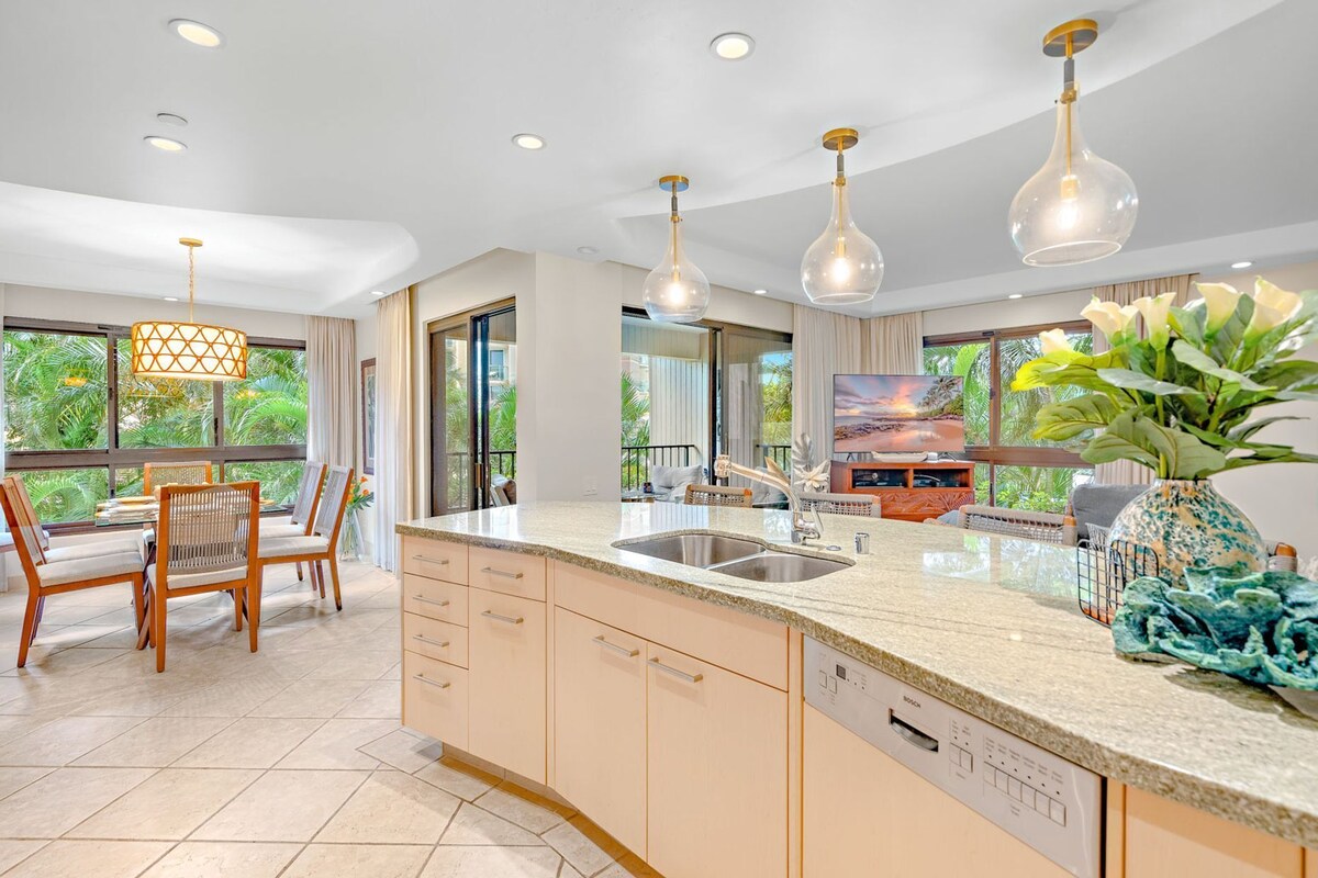 A modern kitchen with a large island, built-in appliances, and pendant lighting.