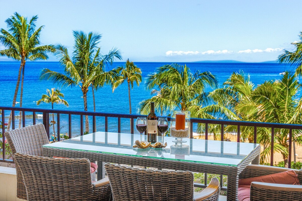 A balcony with wicker furniture, a glass table, and a bottle of wine.