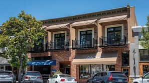 A multi-story building with a brick facade, storefronts, and balconies. - Paso Park Suites by Avantstay Park-view Balcony Downtown Paso Robles (Paso Robles)