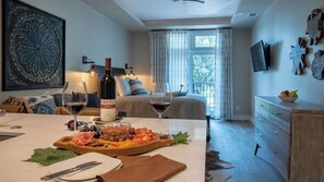 A hotel room with a dining area, a bed with a view, and a minibar. - Paso Park Suites by Avantstay Park-view Balcony Downtown Paso Robles (Paso Robles)