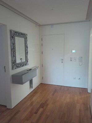 A room with a white door, a mirror with an ornate frame, a built-in bench, and a radiator. - Beautiful Atlantic Days (Moledo)