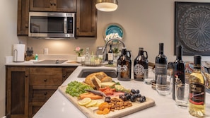 A kitchen with a microwave, sink, and various food items on the counter. - Paso Park Suites by Avantstay Balcony Over the Square + Walkable Paso Robles (Paso Robles)
