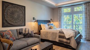 A bedroom with a bed, a sofa, a coffee table, and a large window with curtains. - Paso Park Suites by Avantstay Balcony Over the Square + Walkable Paso Robles (Paso Robles)