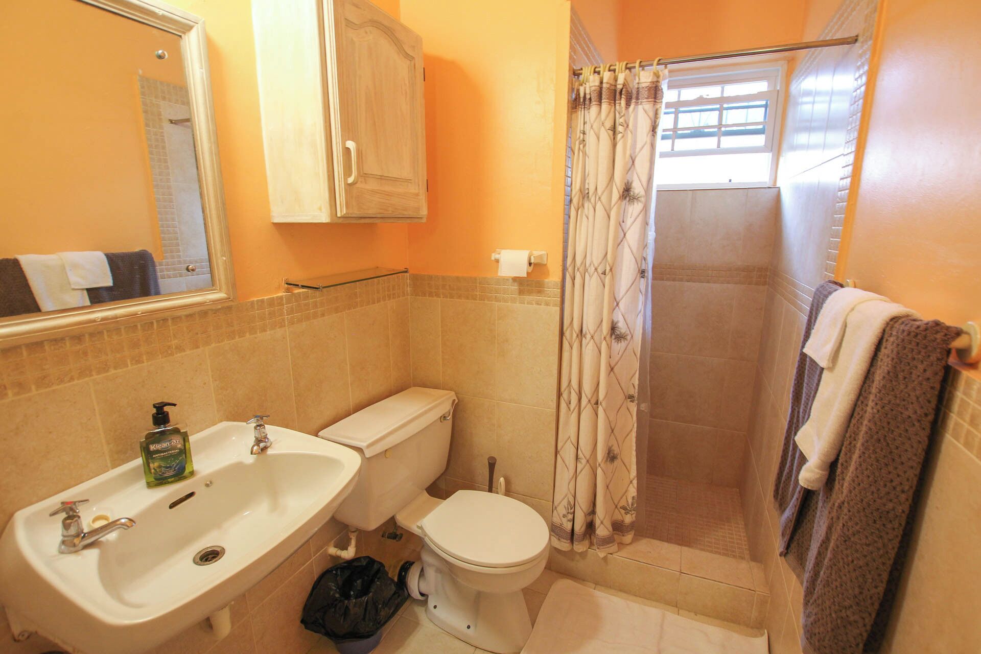 Un baño con lavamanos, inodoro y ducha.