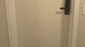 Puerta cerrada con cerradura digital y un cartel azul con números.