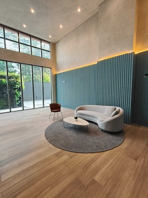 A modern living room with a curved sofa, a small round coffee table, and a chair.