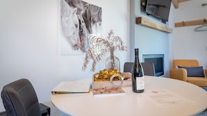 A round table with a wine bottle, a glass vase with dried branches, a notebook, and a menu. - Cocavin Carriage House by Avantstay Gated Vineyard Ranch + Fire Pit + BBQ Paso Robles (Paso Robles)
