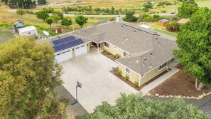 Ein zweistöckiges Haus mit Garage, Solaranlage und einem Basketballkorb auf der Auffahrt.