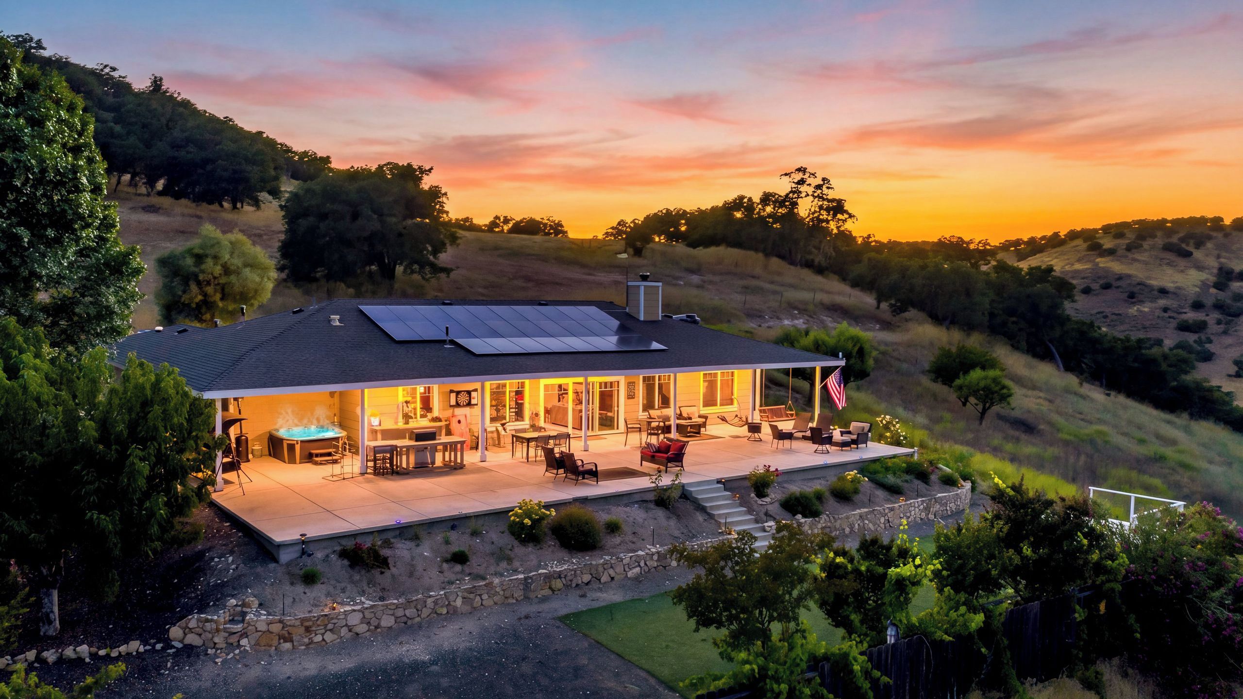 A house with a patio, outdoor seating, and a swimming pool.