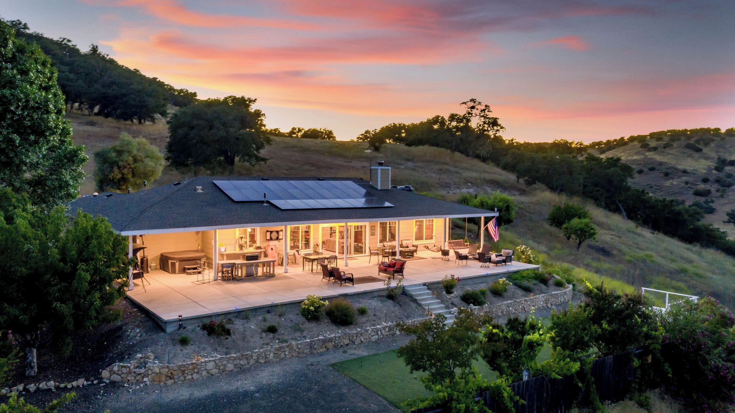 A house with a patio, outdoor seating, and solar panels.