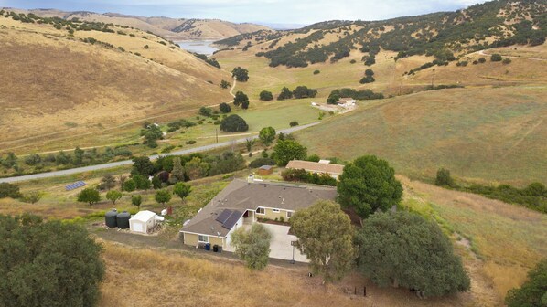 A rural property with a main house, solar panels, and a small barn.