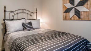 A bed with a metal frame, striped bedding, and two pillows. - The J's Nest Cottage by Avantstay Canyon Views + BBQ Paso Robles Wine Country (Paso Robles)