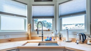 A kitchen with a sink, faucet, and window views. - The J's Nest Cottage by Avantstay Canyon Views + BBQ Paso Robles Wine Country (Paso Robles)