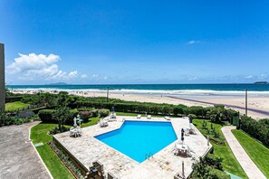 A swimming pool with a view of the beach and ocean. - Charming Apartment With Barbecue Por0101 (Florianópolis)
