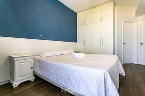 A bedroom with a bed, nightstand, and wardrobe. - Apto With Panoramic View of the sea Front Por204 (Florianópolis)