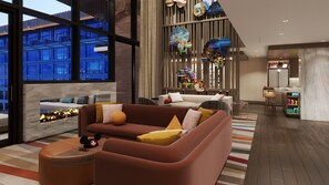 A modern living room with a sofa, ottoman, and a fireplace.